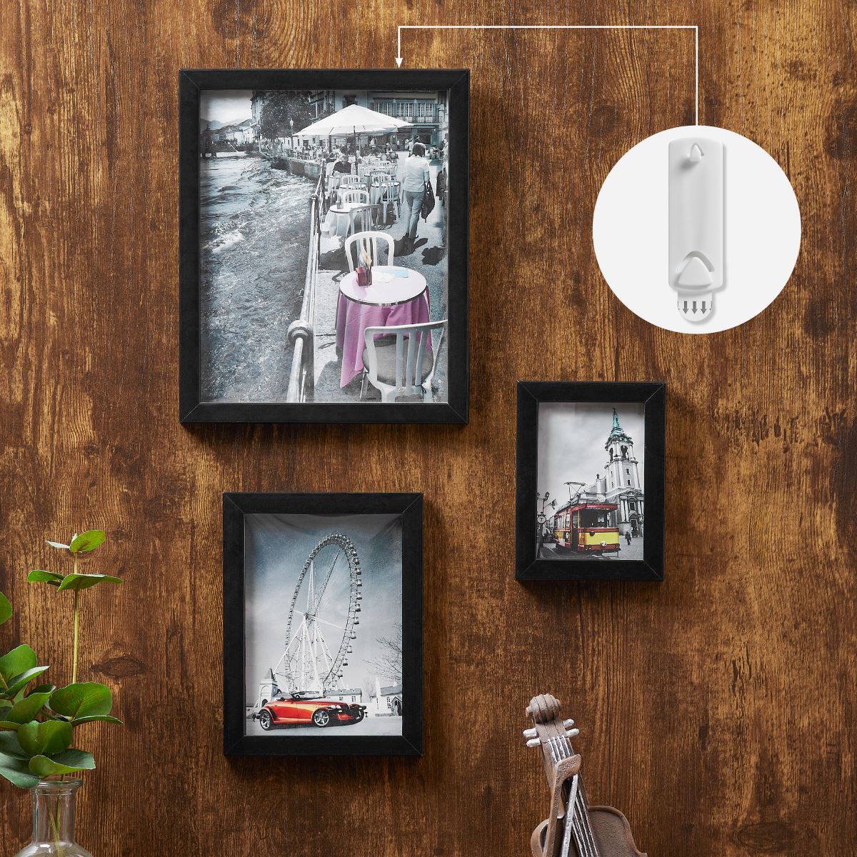 Three picture frames are mounted on the wall, with one highlighted by an arrow showing it is hung using a picture hanger for sawtooth and wire back frames.