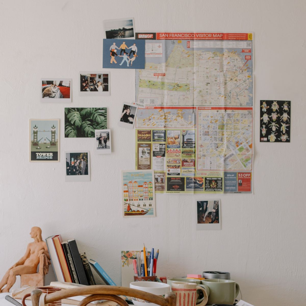 Above the desk, the wall is decorated with numerous postcards attached using removable refill strips.